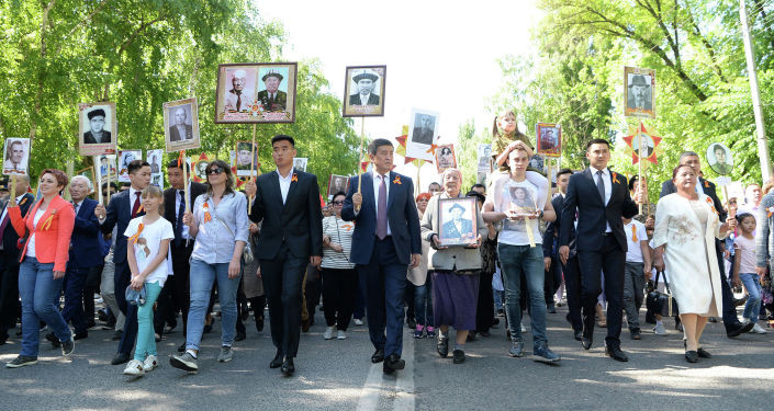 "Өлбөс полк" акциясында Жээнбековдун жанында сүрөт көтөрүп баскан жигит ким?